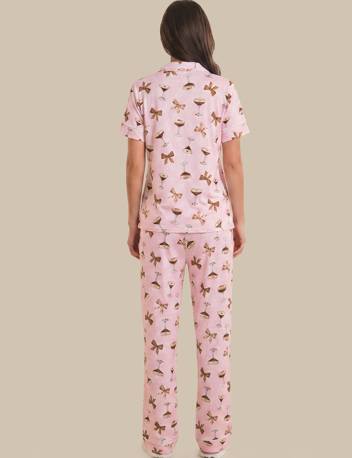 Woman wearing a pink pajama set with a pattern on a beige background