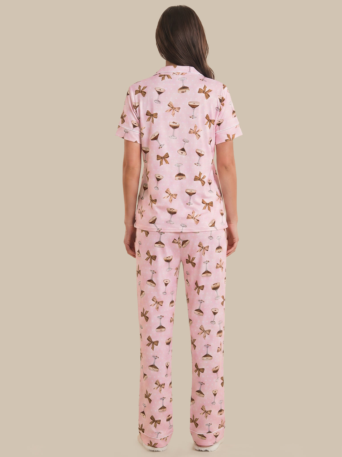 Woman wearing a pink pajama set with a pattern on a beige background