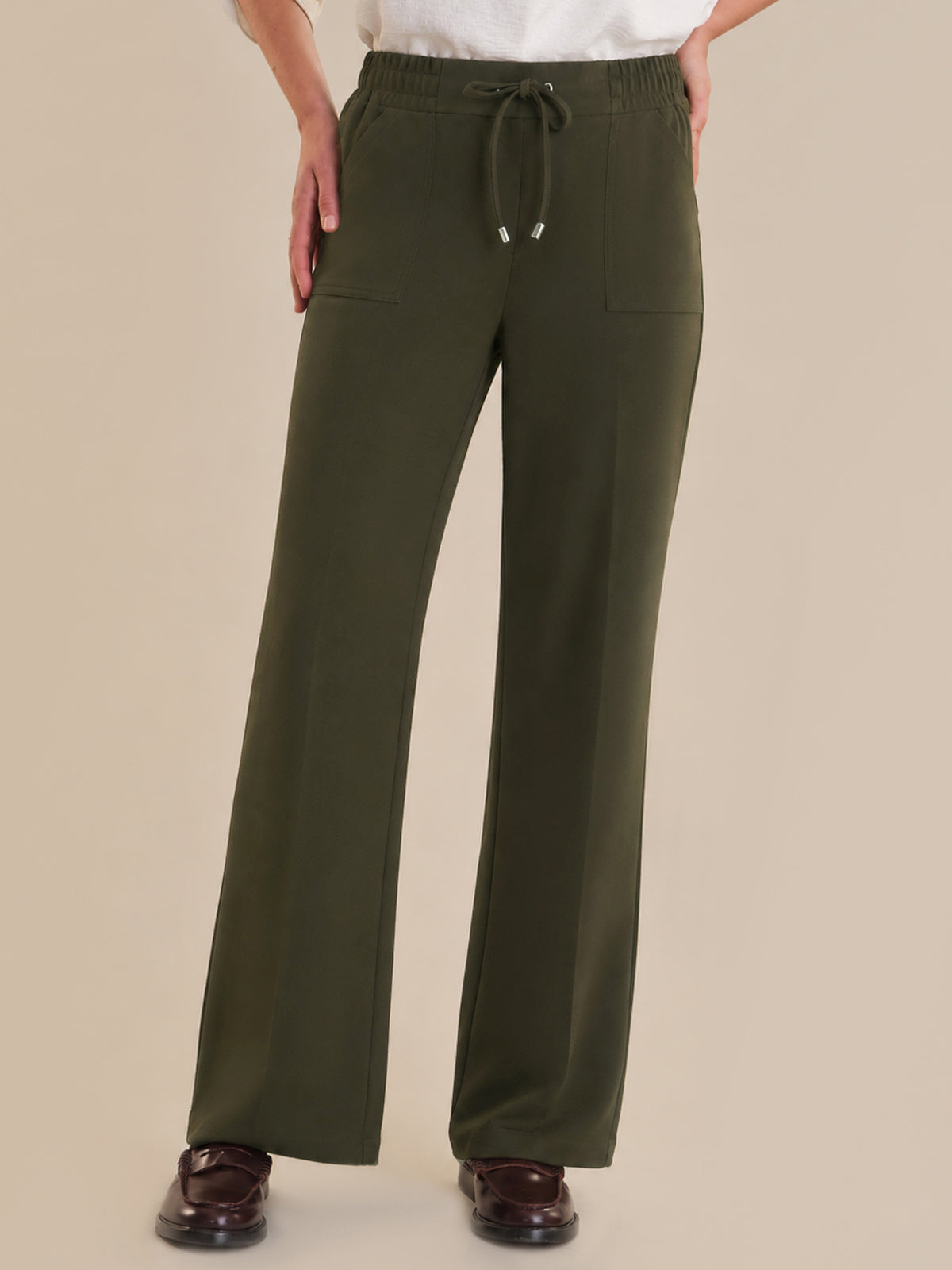 Green pants with a drawstring on a beige background