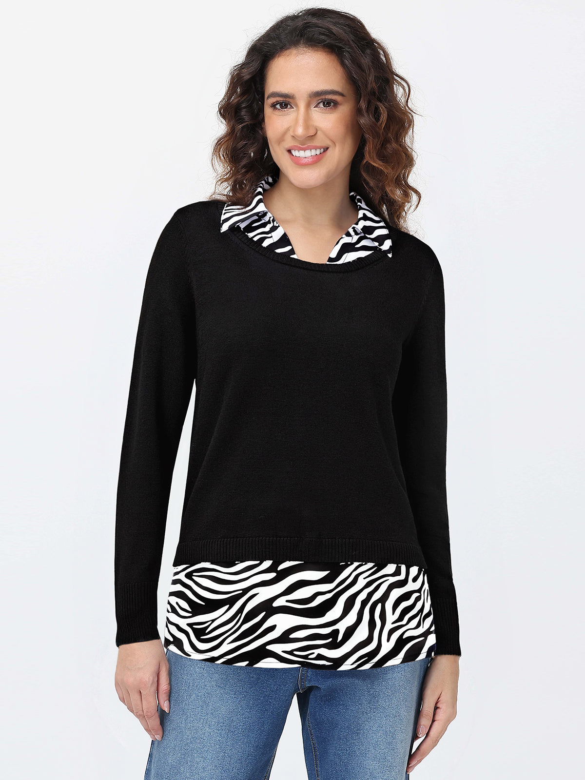 Woman wearing a black sweater with zebra print accents on a white background