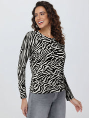 Woman wearing a zebra print cardigan and gray pants on a white background