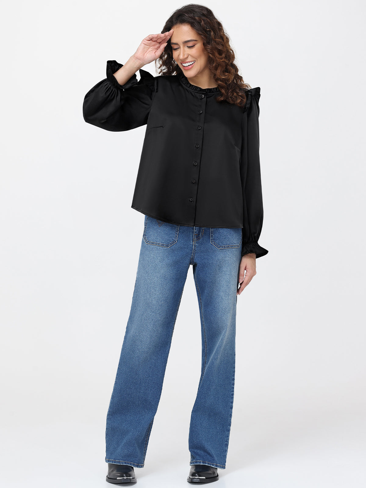 Woman wearing a black blouse and blue jeans on a white background