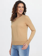 Woman wearing a beige sweater and blue jeans on a white background