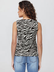 Woman wearing a zebra print sleeveless top and blue jeans on a white background